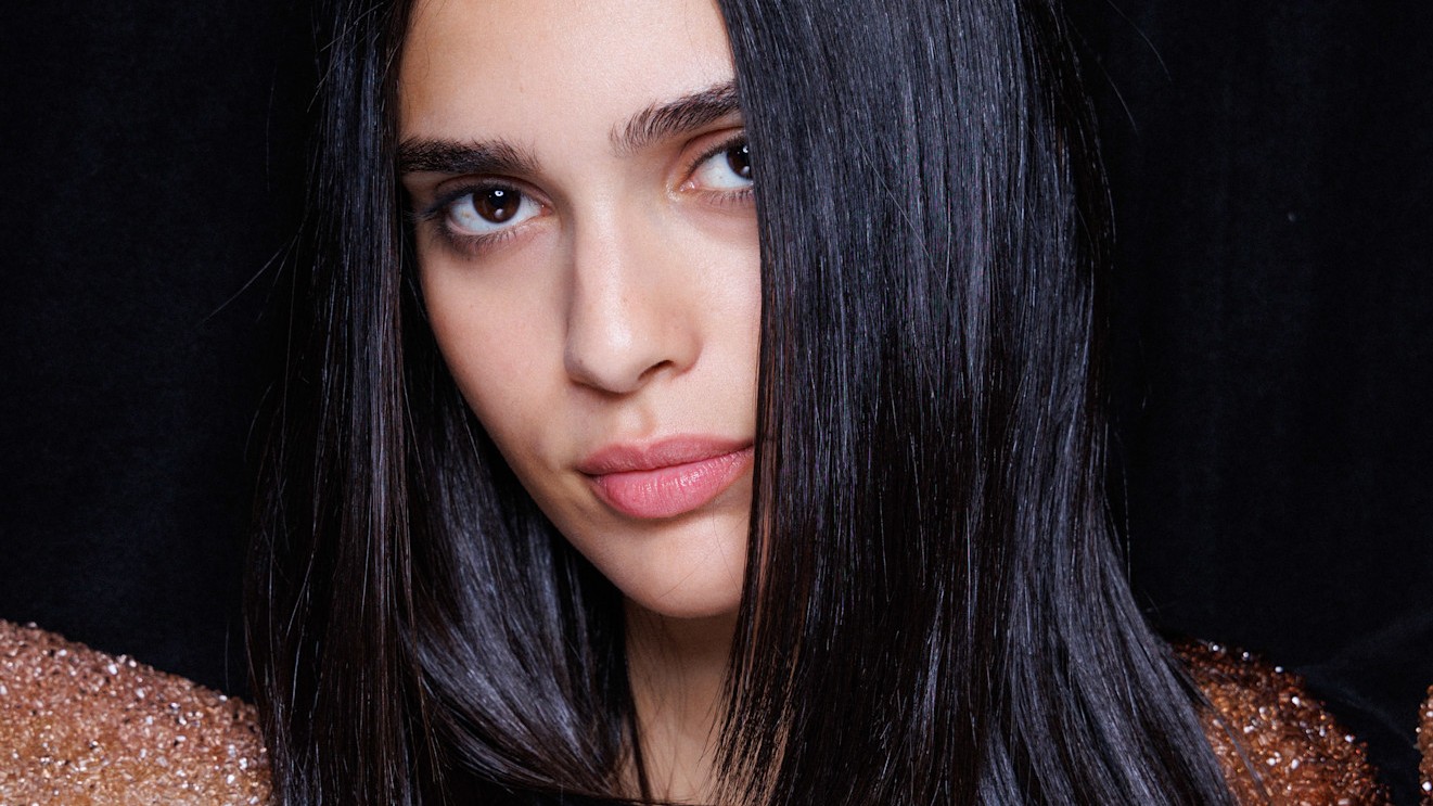 A model with silky straight dark hair, as if she just used a keratin treatment.