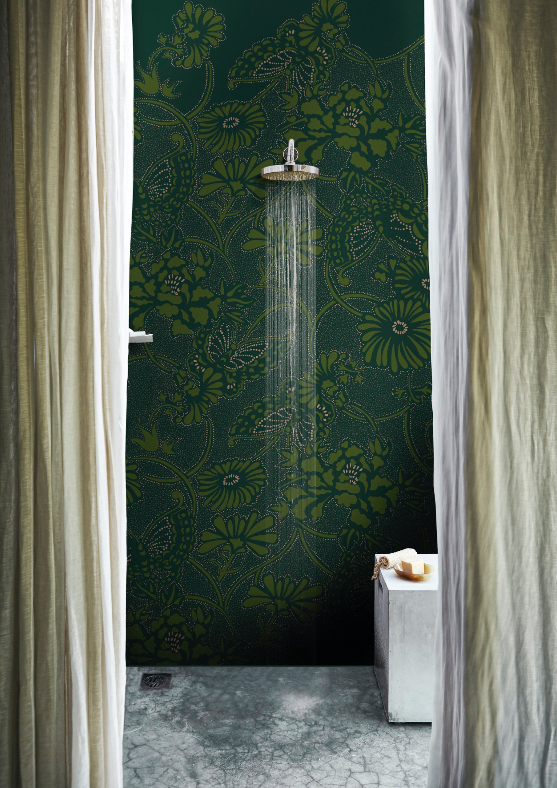 Walk-in shower with a seamless mottled gray floor and a dark patterned feature wall.