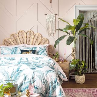 Bedroom with rattan headboard in front of pink panelled wall