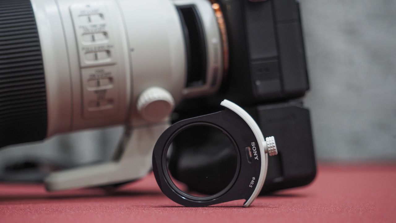 Sony FE 300mm f/2.8 GM OSS lens on a red table with grey curtains