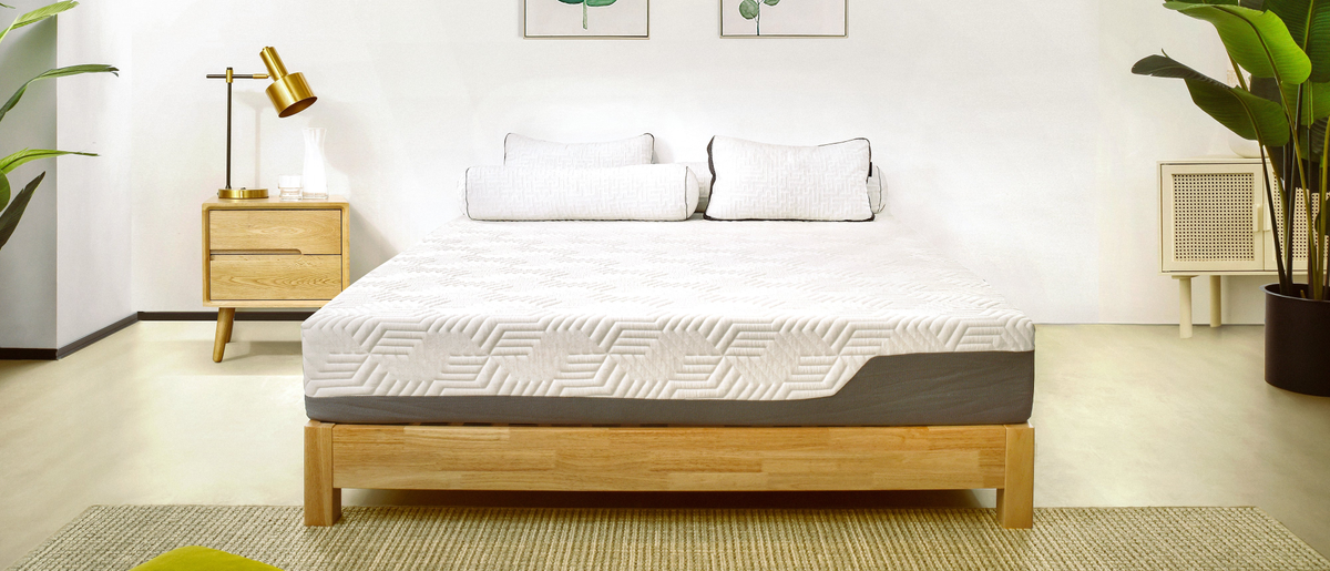 Valmori Hybrid II mattress in lifestyle bedroom setting with pot plant and lamp on one side