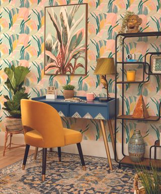 A home office with mustard velvet upholstered chair, bold ethnic inspired wallpaper and statement console