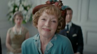 Lesley Manville smiles with delight at a fashion show in Mrs Harris Goes To Paris.