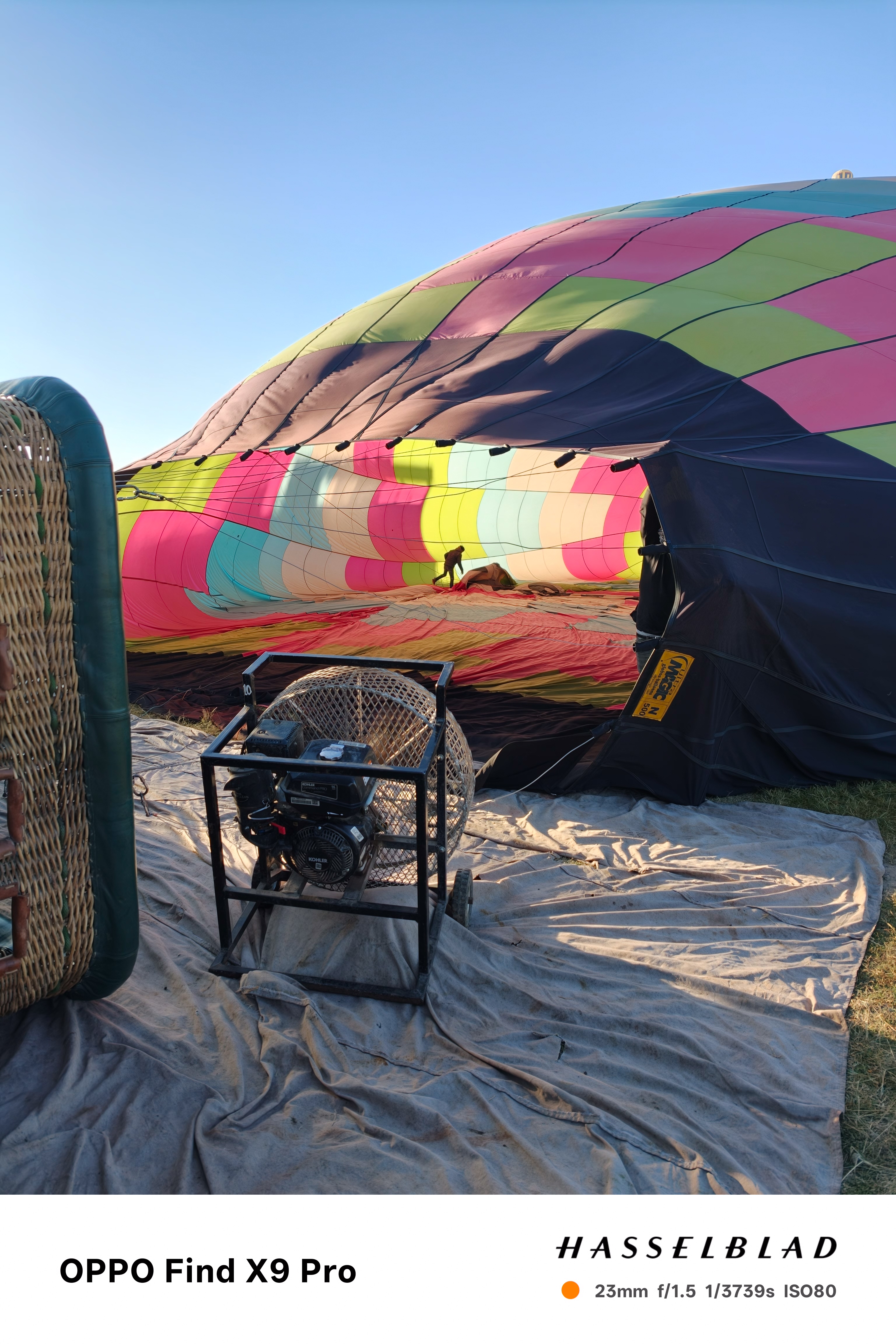 A team of people working to inflate a hot air balloon with a fan