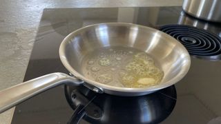 The frying pan from the Made In 10-piece Stainless Steel Pan Set melting butter