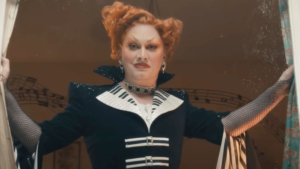 Jinkx Monsoon as Maestro in Doctor Who opening curtains and smirking.