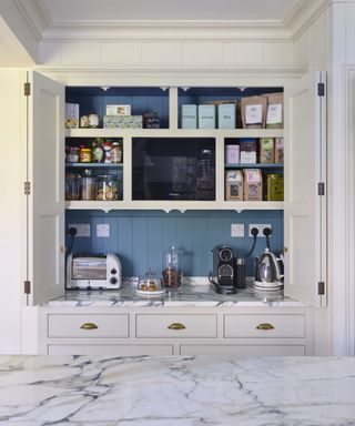 White kitchen cabinet with open doors and blue interior