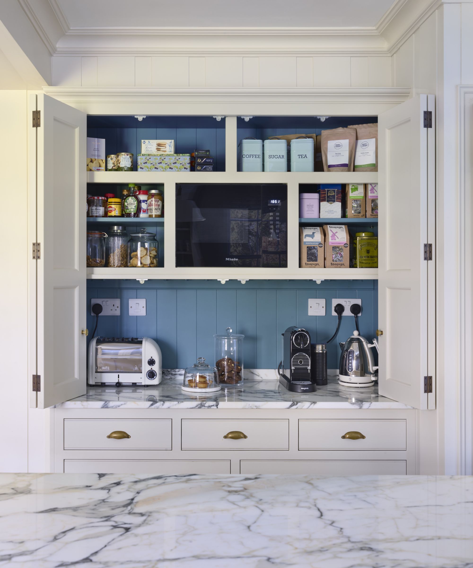 White kitchen cabinet with open doors and blue interior