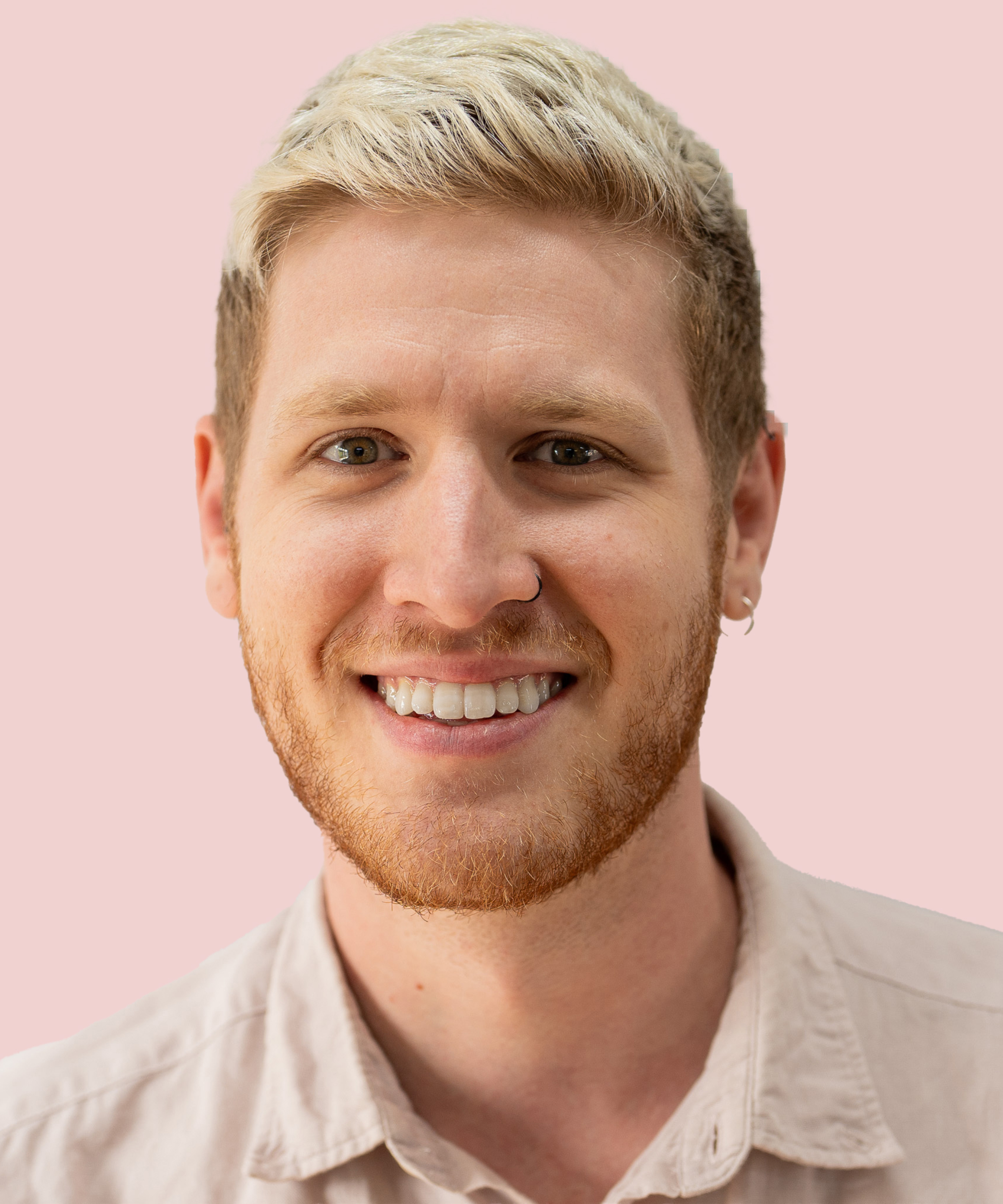 male with short blond hair, short beard and earing wearing pink shirt