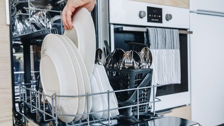 Open dishwasher with clean glasses and dishes close-up after washing