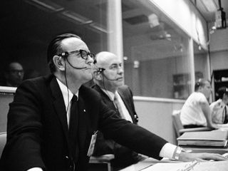Dr. Robert R. Gilruth (right), MSC Director, sits with Dr. Christopher C. Kraft Jr., MSC director of flight operations, at his flight operations director console in the Mission Control Center during the Apollo 5 unmanned space mission.