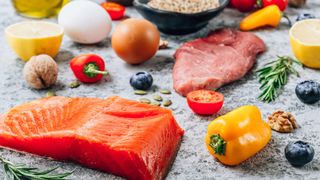Image shows a variety of low FODMAP foods including peppers, salmon, meat and eggs