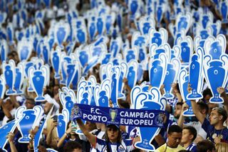 Fans of FC Porto hold cardboard cutouts of the UEFA Champions League trophy during the UEFA Champions League match between FC Porto and FC Barcelona at Estadio do Dragao on October 04, 2023 in Porto, Portugal.