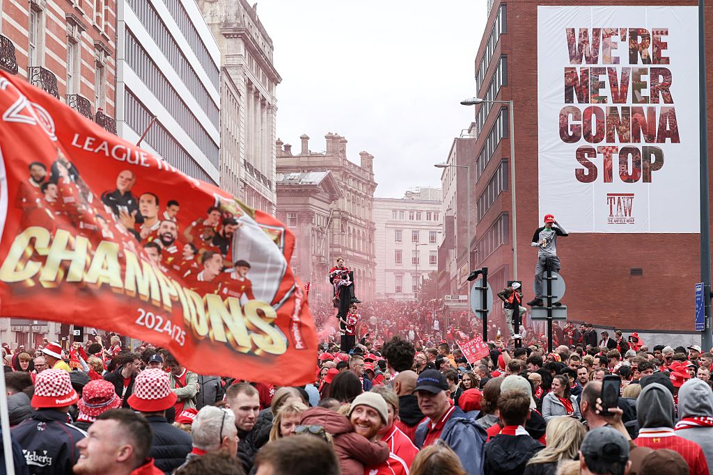 Liverpool supporters celebrate as they wait for the open-top bus victory parade for Liverpool's Premier League title win, in Liverpool, north-west England on May 26, 2025.