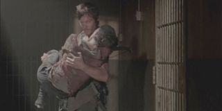 Daryl saving Carol in the prison in The Walking Dead.