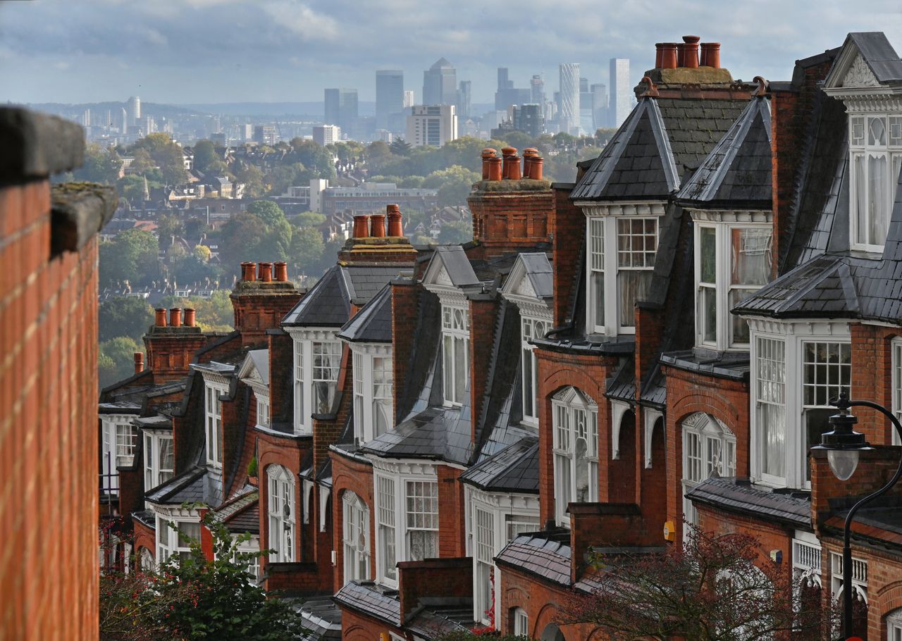 Row of houses in Muswell Hill, north London, with view of Canary Wharf behind