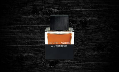 Encre Nore à l’Extrême bottle set against a black wooden grain background