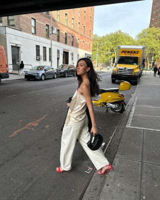 Woman in silk top and white jeans.