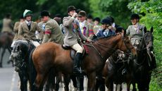 Rider drinking out of hip flask on horseback