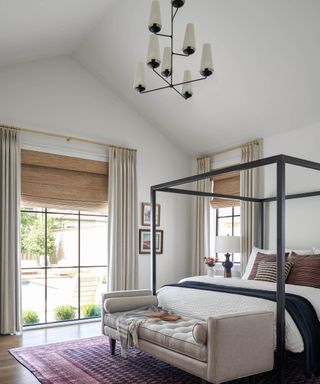 Bedroom with four poster bed, daybed and chandelier on vaulted ceiling