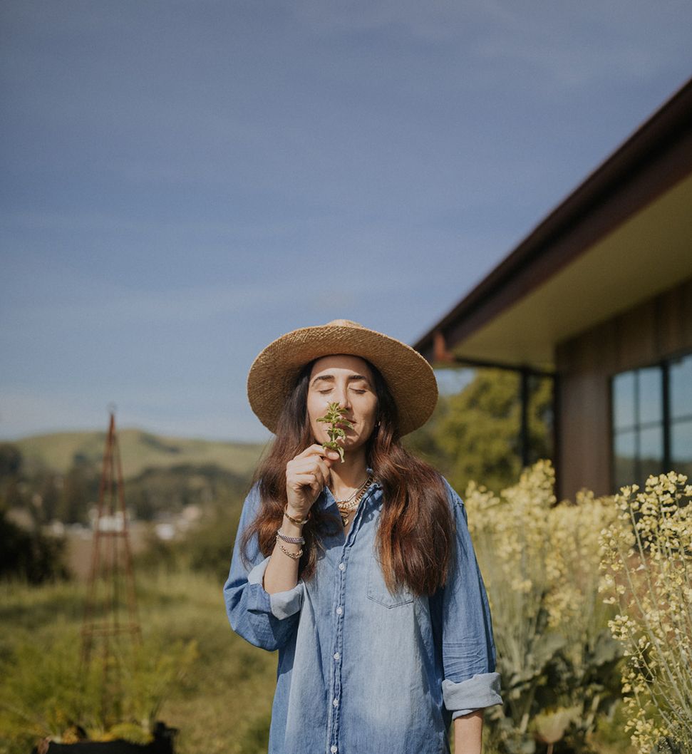 Image of April Gargiulo in the garden smelling a flower