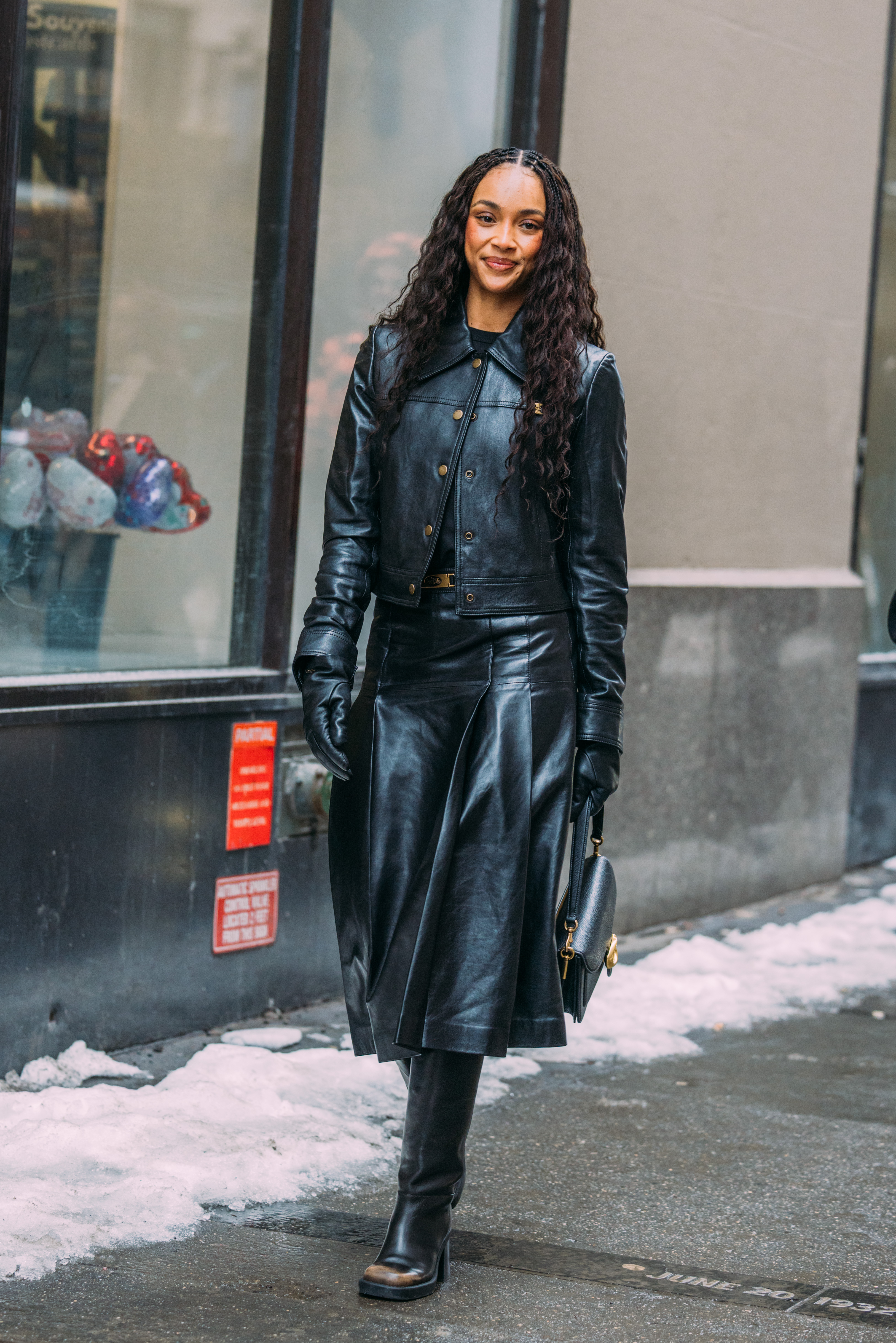 a woman wears a leather jacket during fashion week.