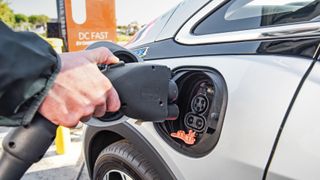 Close-up of someone plugging a charging into the port of the Chevrolet Bolt EV