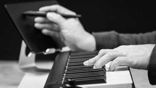 Person at keyboard writing a song