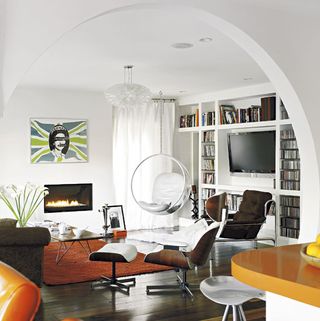 living room with white wall book shelve chairs and wooden flooring
