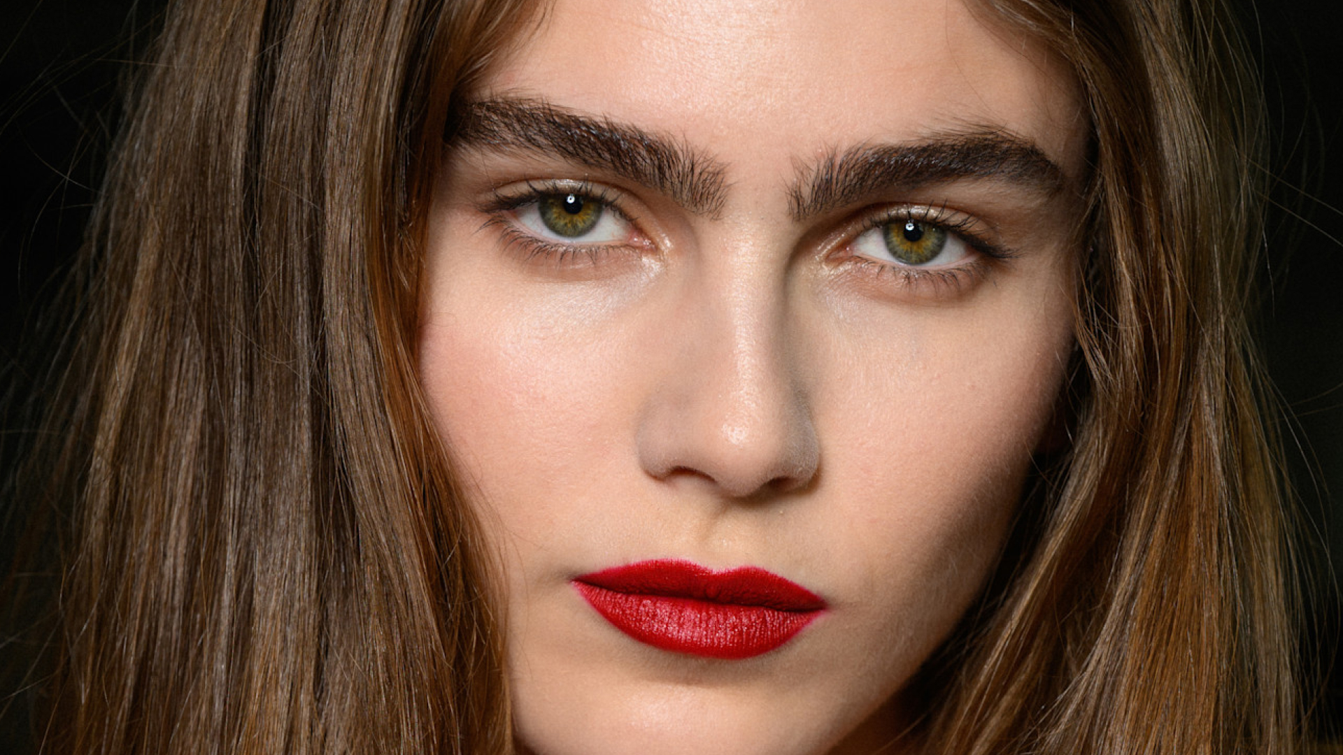 A model wearing red lip liner and lipstick.