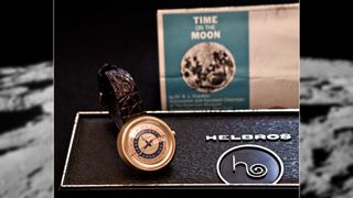 a watch in a box in front of a sign reading "Time on the moon"