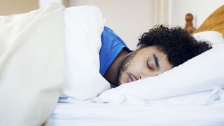 Young man asleep on his side in bed