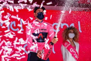 Team Ineos rider Italys Filippo Ganna wearing the overall leaders pink jersey celebrates on the podium after winning the first stage of the Giro dItalia 2021 cycling race a 86 km individual time trial on May 8 2021 in Turin Photo by Luca Bettini AFP Photo by LUCA BETTINIAFP via Getty Images