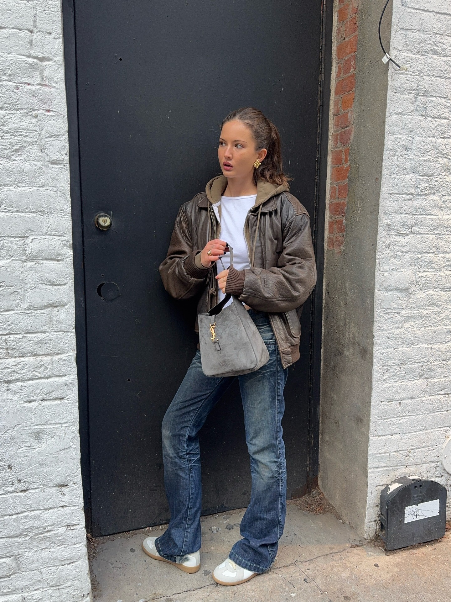 @rubylyn_ wearing bootcut jeans and sporty sneakers.