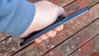 An Oppo Reno 8 Pro smartphone sitting on a rustic table