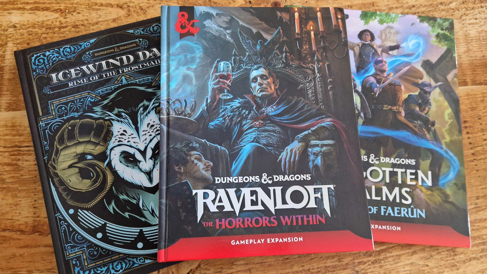 Three D&amp;D books laid out on a wooden surface