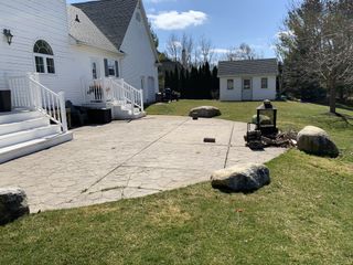 The before shot a backyard in Ontario with a view of the lawn, patio and shed