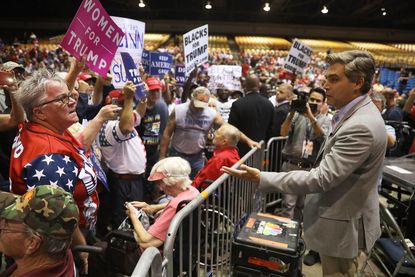 A woman yells at CNN's Jim Acosta before a Trump rally in Tampa.
