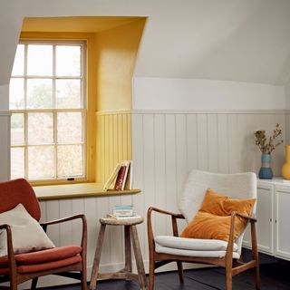 white living space with two armchairs, table and yellow window area
