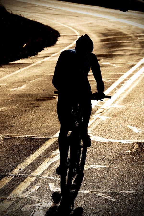 A rider rides off in to the sunset on the tough stage.