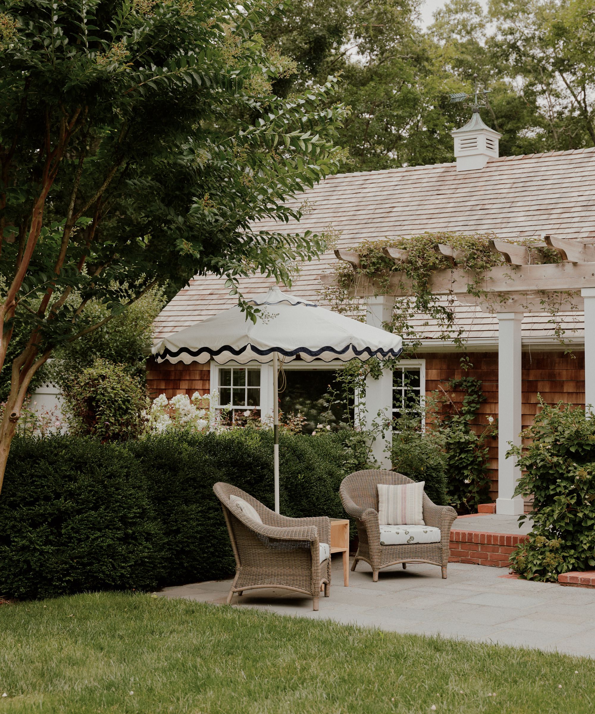cottage exterior with parasol and basket chairs