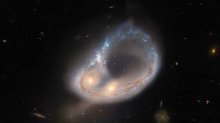 A close-up image of the galaxy merger Arp-Madore 417-391 that was recently taken by the Hubble space telescope. A near-perfect ring of stars has been created by the gravitational forces of the massive cosmic collision.