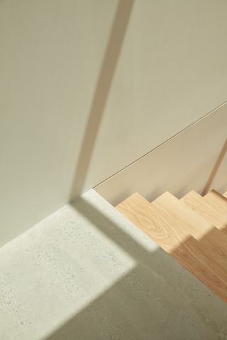 Wooden staircase with a shadow of the railing