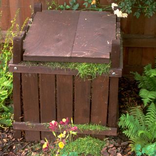garden with wooden compostbin and copost heap