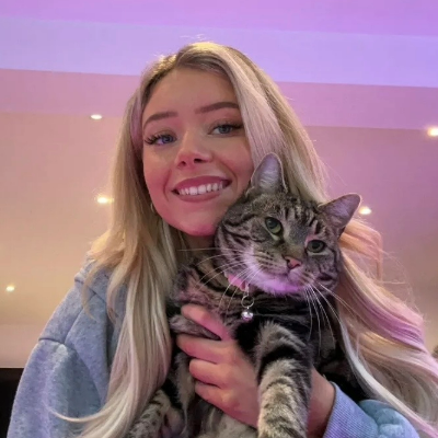Megan Milstead, staff writer at Petsradar, smiling and holding her cat Nala