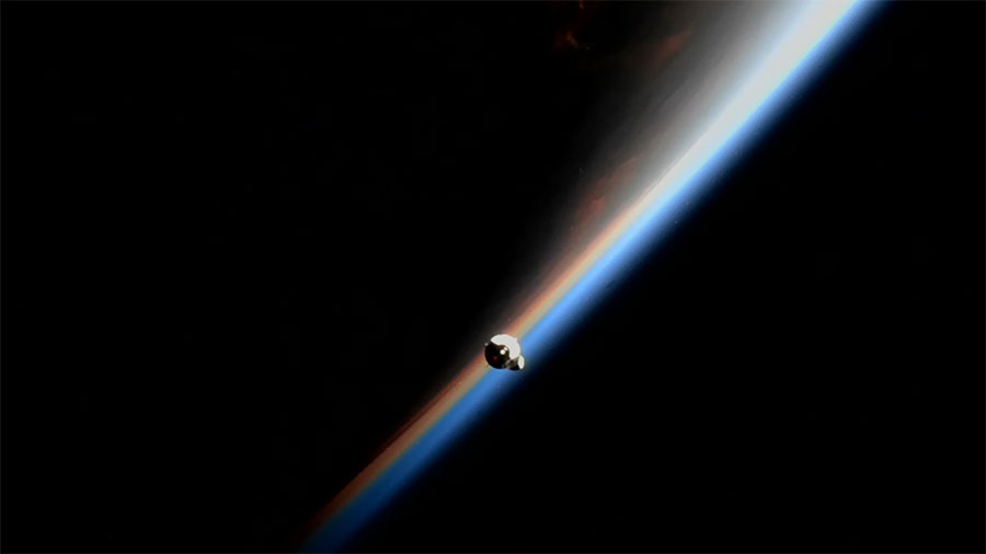 The SpaceX-25 Dragon cargo ship with a sliver of Earth illuminated by the sun in the background on July 16, 2022.