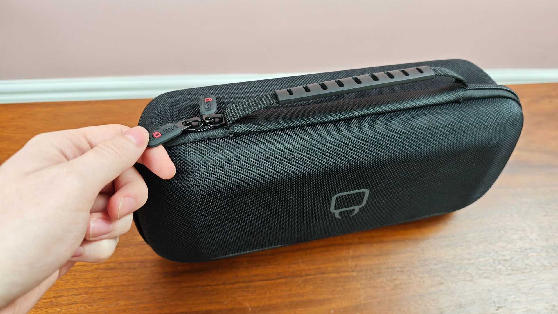 Man zipping up the Venom PlayStation Portal Carry Case