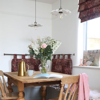 Kitchen with fluted pendant lights over table.