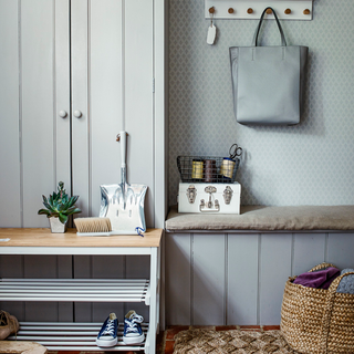 boot room with white cupboard and shoe rack with bench