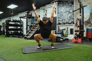 Fitness coach performing a bodyweight sumo squat